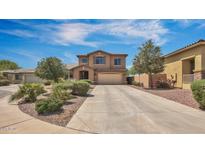 Charming two-story home with neutral stucco, landscaped front yard, and a spacious driveway leading to an attached two-car garage at 41763 W Mano Pl, Maricopa, AZ 85138