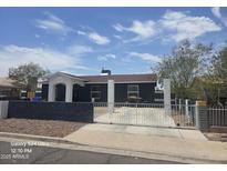 Charming single-story home featuring a secure decorative white fence, dark painted exterior, and a well-maintained landscape at 5242 S 12Th Ave, Phoenix, AZ 85041