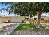 Charming single-story home featuring a two-car garage, brick accents, and mature landscaping at 12814 W Copperstone Dr, Sun City West, AZ 85375