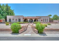 Charming single-story home featuring a brick exterior, arched entryways, and desert landscaping at 7645 W Bluefield Ave, Glendale, AZ 85308