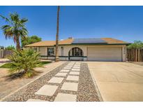 Charming single-Gathering home featuring desert landscaping, a two car garage, and solar panels at 2164 E Jerome Ave, Mesa, AZ 85204