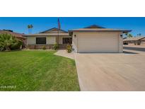 Charming single-Gathering home featuring a two-car garage, manicured lawn, and vibrant rose bushes at 3828 W Port Au Prince Ln, Phoenix, AZ 85053