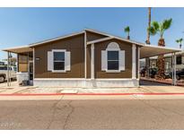 Charming single-story home featuring brown siding, white trim, and a well-maintained front yard at 625 W Mckellips Rd # 411, Mesa, AZ 85201