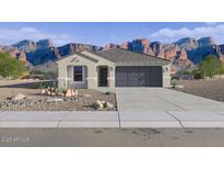 Charming single-story home with a two-car garage and desert landscaping against a backdrop of mountains at 12599 W Mountain View Dr, Avondale, AZ 85323