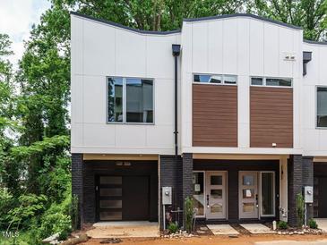Modern townhome featuring brick accents, a single-car garage, and contemporary design elements at 1521 Havenmont Ct, Raleigh, NC 27608
