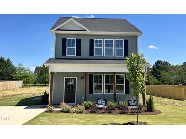Charming two-story home with gray siding, black shutters, and manicured front lawn at 40 Longbow Dr, Middlesex, NC 27557
