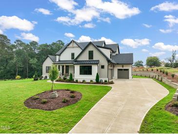 Beautiful new construction home with a manicured front yard and a long driveway leading to the garage at 1804 Stream Manor Ct, Wake Forest, NC 27587