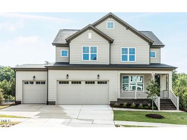 Beautiful two-story home featuring a three car garage, covered porch and manicured lawn at 6059 Scalybark Road, Durham, NC 27712