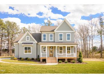 Charming two-story home featuring a welcoming front porch and beautifully landscaped front yard at 30 Imperial Oaks Ct, Youngsville, NC 27596