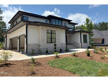 Beautiful home with stone and siding details, an attached garage, and a professionally landscaped front yard at 67 Quail Pt, Pittsboro, NC 27312