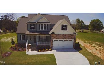 Charming two-story home with gray siding, stone accents, covered porch and white two-car garage at 27 Prency Ln, Middlesex, NC 27557