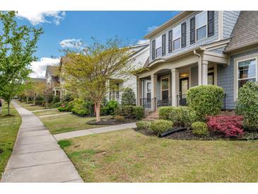 Charming homes line a sidewalk with manicured lawns, creating a welcoming neighborhood street view at 901 Wildflower Ridge Rd, Wake Forest, NC 27587