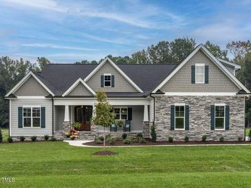 Charming home with stone accents, symmetrical design, and a welcoming front porch at 100 Old Garden Ln, Youngsville, NC 27596