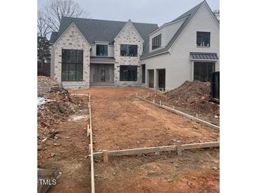 Two-story house with stone and shingle accents, a large driveway, and a three-car garage at 2227 Wheeler Rd, Raleigh, NC 27607