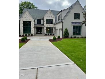 Stunning two-story home with stone accents, black windows, and professionally landscaped front yard at 2227 Wheeler Rd, Raleigh, NC 27607