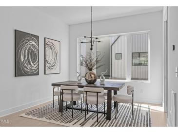 Bright dining room with modern light fixture and black and white striped rug at 2014 Moody Ln, Durham, NC 27701