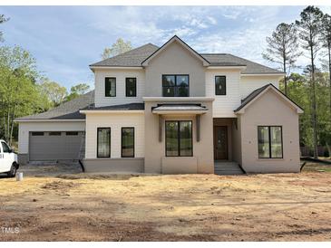 New two story home with gray and white accents, black window frames, and attached two car garage at 2633 Trifle Ln, Wake Forest, NC 27587