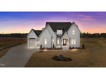 Beautifully landscaped modern farmhouse with a three-car garage, set against a picturesque sunset backdrop at 4909 Hidden Pasture Way, Zebulon, NC 27597