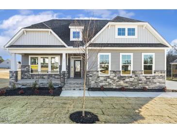 Two-story house with gray siding, stone accents, and a front porch at 55 Browning Mill Dr, Wendell, NC 27591