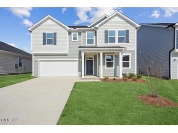Charming two-story home with a well-manicured lawn and a classic architectural design at 305 Chestnut Oak Ln, Lillington, NC 27546