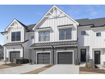 Charming townhome showcases modern architecture with a gray brick facade and attached garages at 4015 Elk Creek Ln, Raleigh, NC 27612