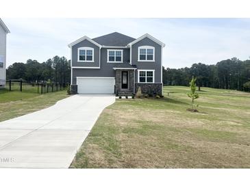 Charming two-story home boasts a modern exterior with gray siding and a well-manicured lawn at 592 Barbour Farm Ln, Four Oaks, NC 27524