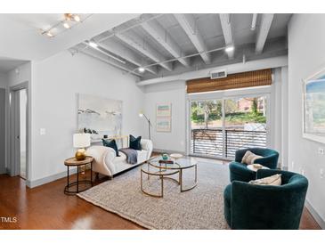 Bright living room with exposed ceiling, modern furnishings and sliding glass door leading to a balcony at 1300 St Marys St # 208, Raleigh, NC 27605