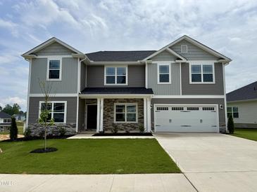 Beautiful two-story home with gray siding, stone accents, and a well-manicured front lawn at 122 Southern Estates Dr, Sanford, NC 27330