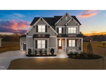 Two-story home with gray siding, landscaped yard, and a three-car garage at 130 Summerlin Dr, Clayton, NC 27527