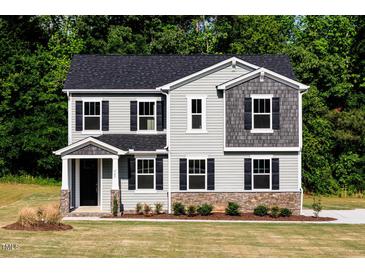 Charming two-story home with gray siding, black shutters, and a well-manicured front lawn at 427 Fast Pitch Ln, Four Oaks, NC 27524