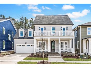 Charming two-story home with a welcoming front porch and balcony, complemented by lush landscaping at 809 St Charles St, Durham, NC 27713