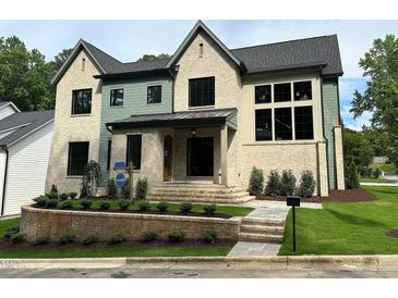 Stunning two-story brick home with a beautifully landscaped front yard and manicured lawn at 1000 Marilyn Dr, Raleigh, NC 27607