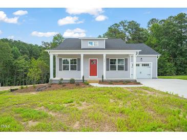 Charming single-story home featuring a red front door, gray siding, and well-manicured lawn at 148 Harmony Trl, Broadway, NC 27505