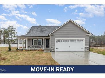 Charming single-story home with gray siding, a front porch, and a two-car garage with white doors and a well-maintained lawn at 106 Burnello Ct, Princeton, NC 27569