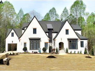 Stunning new construction home featuring a white brick facade, dark window trim, and lush landscaping at 7621 Falls Creek Ln, Raleigh, NC 27614
