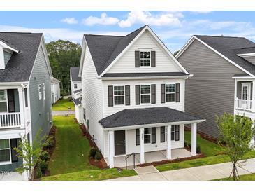 Charming two-story home features a covered front porch, black shutters, and a well-manicured front lawn at 9249 Kitchin Farms Way # 432, Wake Forest, NC 27587