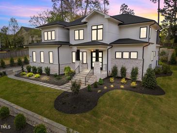 Stunning two-story home featuring stone accents, manicured lawn, and a grand entrance at 861 Wimbleton Dr, Raleigh, NC 27609