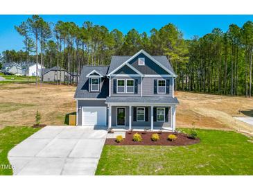Charming two-story home with gray siding, white trim, and a well-manicured front lawn at 457 Duncan Creek Rd # 141, Lillington, NC 27546