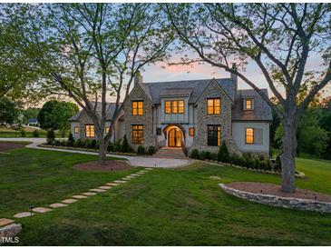 Stunning stone and shingle home boasts mature trees, manicured lawn, and inviting stone walkway at 1641 Legacy Ridge Ln, Wake Forest, NC 27587