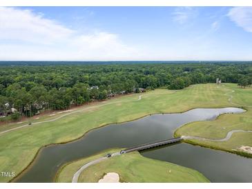 Aerial view of a golf course community with a pond and houses at 90 Brandon Dr, Lillington, NC 27546
