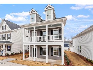 Charming two-story home with a covered porch, perfect for enjoying the outdoors at 9301 Kitchin Farms Way # 433, Wake Forest, NC 27587