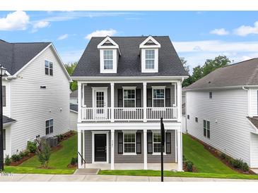 Charming two-story home with a welcoming front porch, dormer windows and manicured lawn at 9301 Kitchin Farms Way # 433, Wake Forest, NC 27587