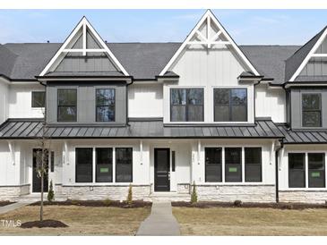 Charming townhome featuring a stone accent base, gabled roof lines, and beautifully landscaped yard at 320 Church St, Morrisville, NC 27560