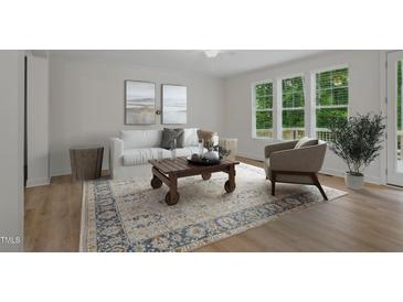 Bright living room with hardwood floors, a neutral rug, and large windows offering abundant natural light at 146 Wood Wedge, Sanford, NC 27332