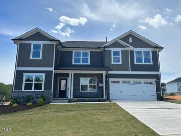 Inviting two-story home featuring a two-car garage and a well-manicured front lawn at 136 Newport Lndg, Garner, NC 27529