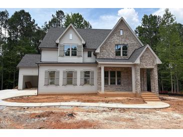 Charming two-story home with brick and siding, featuring a covered front porch and attached garage at 162 Gaines Trail, Pittsboro, NC 27312