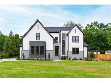 Beautifully landscaped two-story home with a well-manicured lawn and gray and white exterior at 5812 Shawood Dr, Raleigh, NC 27609
