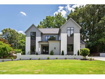 Beautiful two-story home featuring modern design elements and lush green lawn at 5208 Knollwood Rd, Raleigh, NC 27609