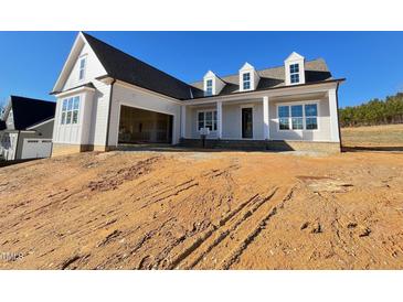 Two-story house with a light gray exterior, a large front porch, and a two-car garage at 6052 Scalybark, Durham, NC 27712