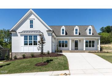 Inviting new construction home featuring a manicured lawn and a long concrete driveway at 6052 Scalybark Rd, Durham, NC 27712